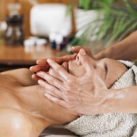 Woman enjoying a professional ayurvedic facial massage with therapeutic oils